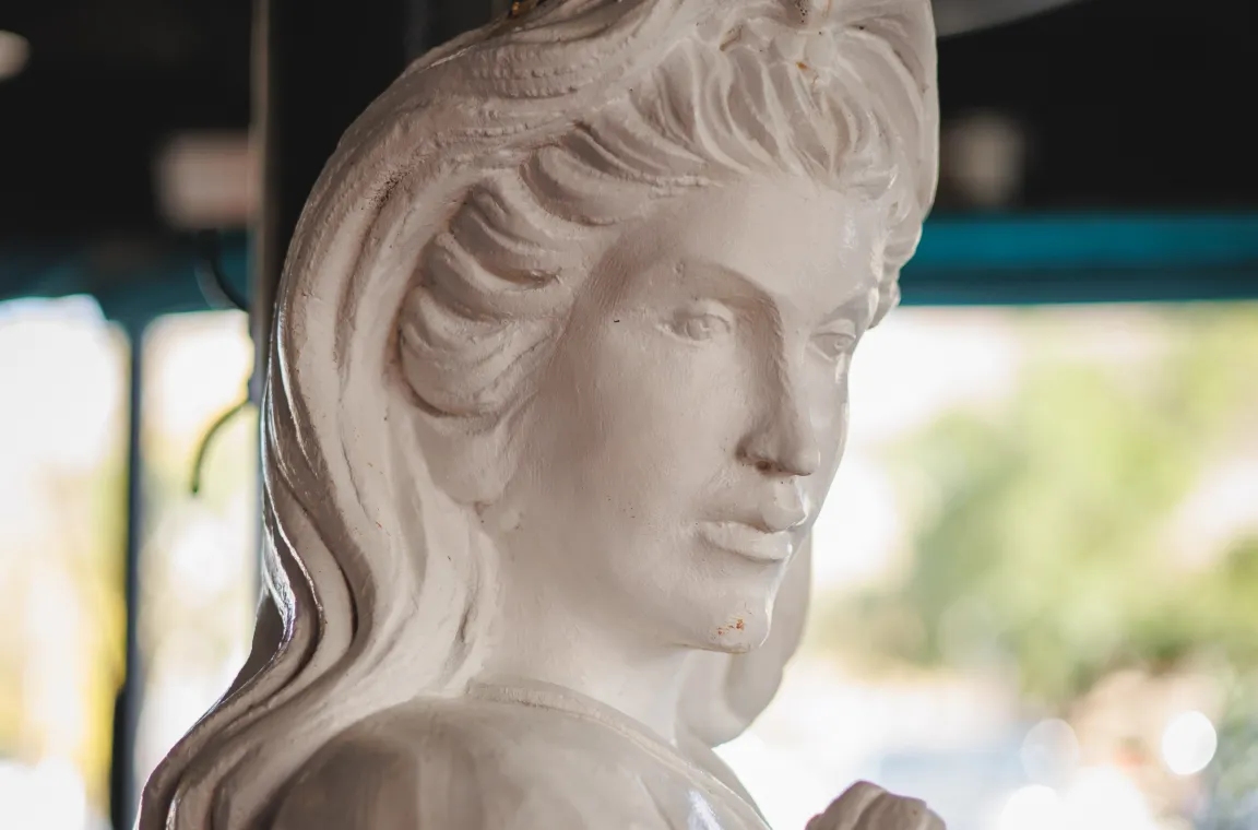 Close-up of a white classical-style statue inside Soluna restaurant, softly lit with a blurred dining room in the background.