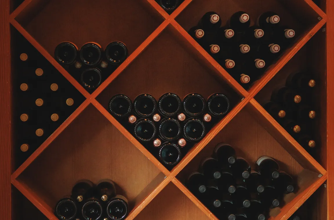 Geometric wooden wine rack filled with bottles in the wine cellar at Bliss restaurant in San Antonio.