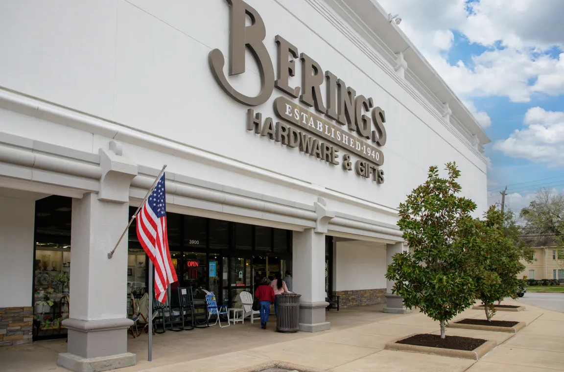 Exterior of Bering's Hardware & Gifts in Houston featuring the storefront entrance, American flag, and landscaped sidewalk.