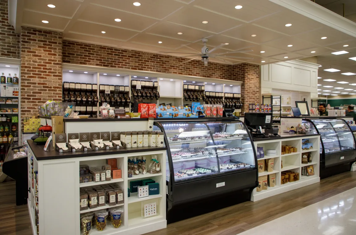 Gourmet food and candy section inside Bering's Hardware & Gifts with refrigerated dessert displays, specialty chocolates, and coffee selections.