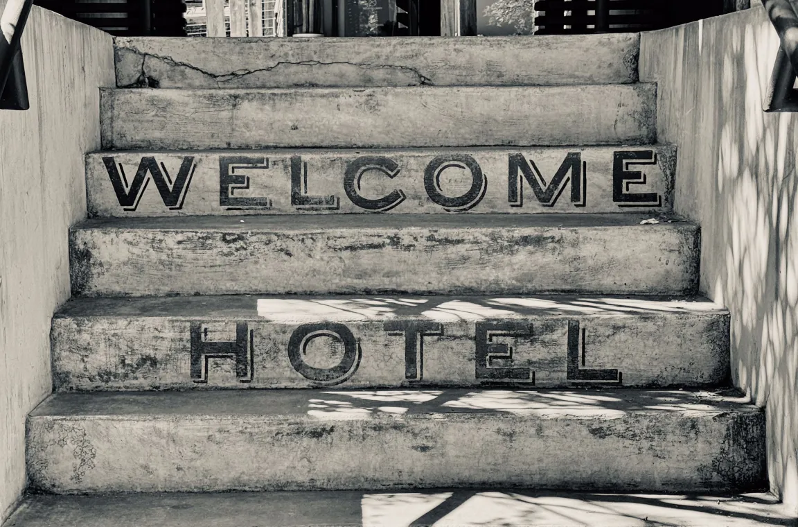 Concrete staircase at Hotel San José with “Welcome Hotel San José” painted across the steps, leading to the hotel entrance beneath a shaded pergola.