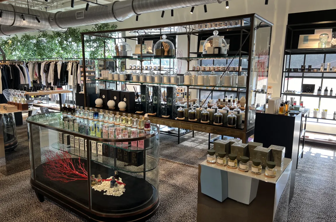 Luxury fragrance and home goods display inside The Conservatory at Highland Park Village with curated perfumes, candles, and designer merchandise.