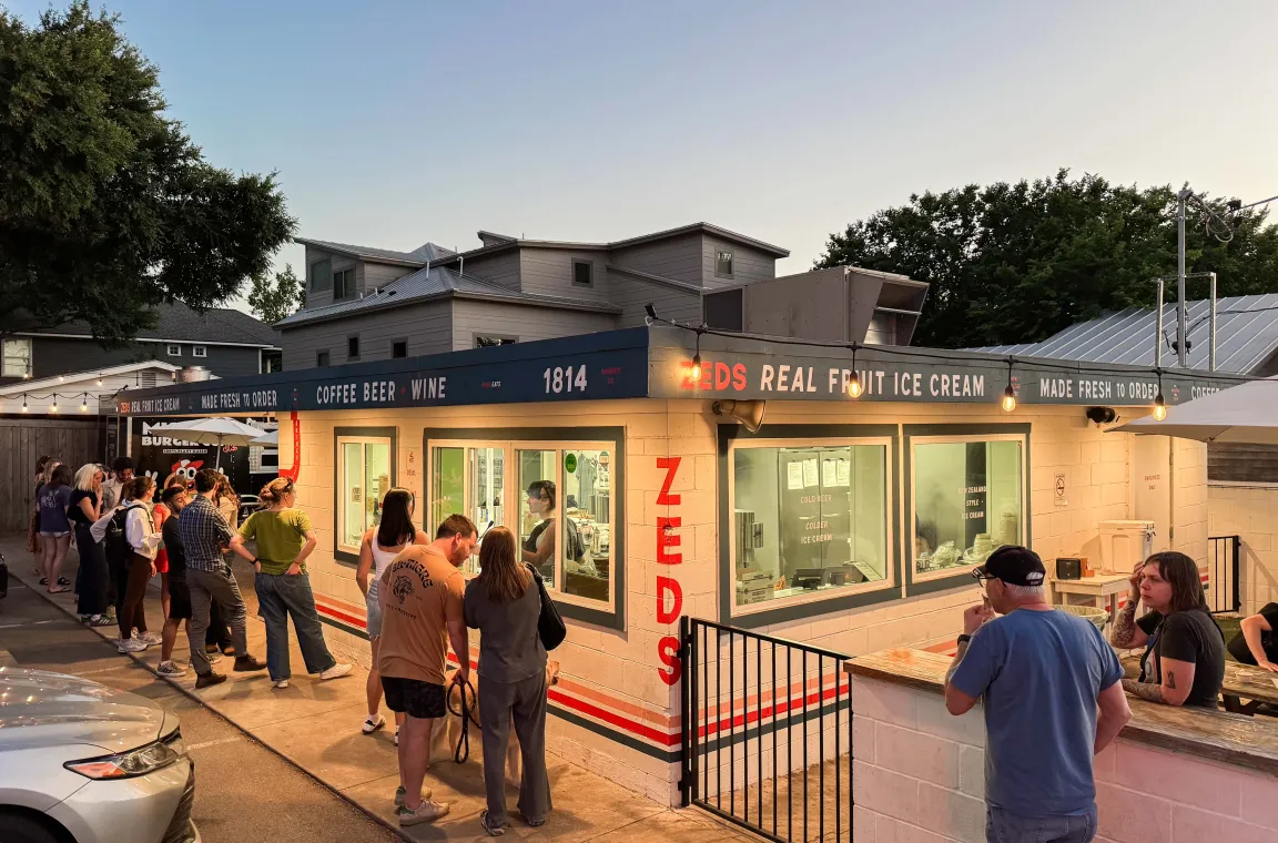 Exterior of Zed's Real Fruit Ice Cream featuring evening crowds, walk-up ordering windows, and the popular neighborhood ice cream stand.