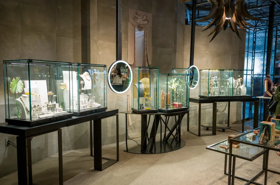 Interior of Grange Hall in Dallas featuring illuminated glass display cases showcasing handcrafted jewelry and artisan accessories in a contemporary retail space.
