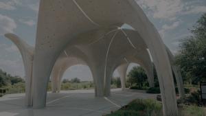 Photograph of the Confluence Park pavilion in San Antonio, showcasing sweeping concrete petal-shaped arches and dramatic geometric symmetry.